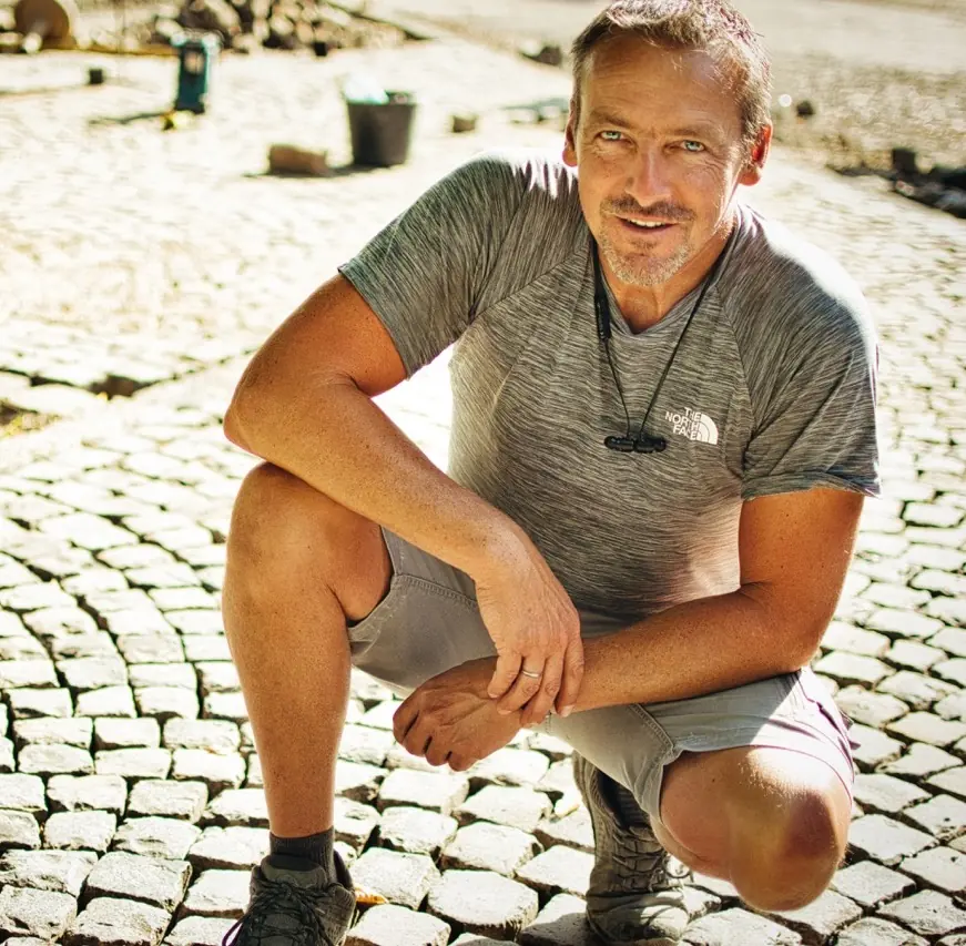 Natursteinmeister Dirk Graupmann auf einer Natursteinpflasterfläche.